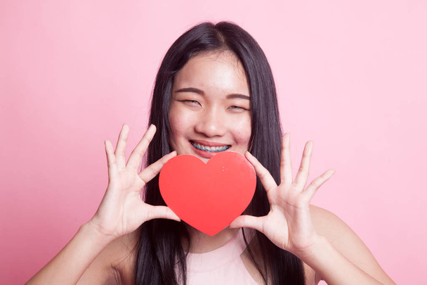 Asian woman with red heart on pink background - Foto, immagini