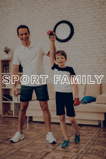 Father Is Lifting Up Son's Hand. Victory Concept. Father And Son Boxing Training. Sports Family. Healthy Lifestyle. Active Holiday. Young Winner. Working Out At Home. Kid With Fight Gloves. - Φωτογραφία, εικόνα