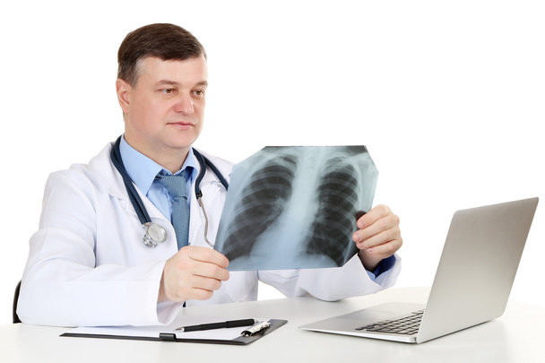 Medical doctor analysing x-ray image at desk isolated on white - Photo, image