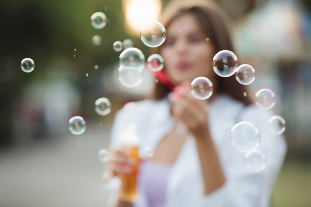 Happy adult girl blowing bubbles - Fotoğraf, Görsel