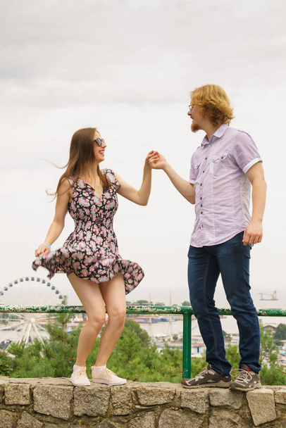 Joyful couple having fun outdoor. Young man and woman dancing jumping together during date. - Zdjęcie, obraz