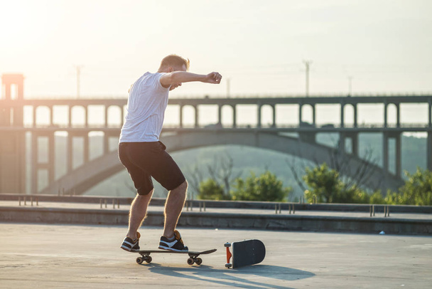 Skateboarder doing a trick in a jump at sunset. Active lifestyle. - Fotoğraf, Görsel