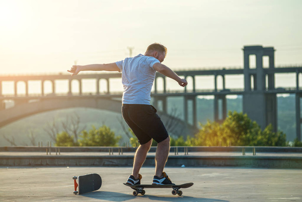 Skateboarder doing a trick in a jump at sunset. Active lifestyle. - Foto, Imagen
