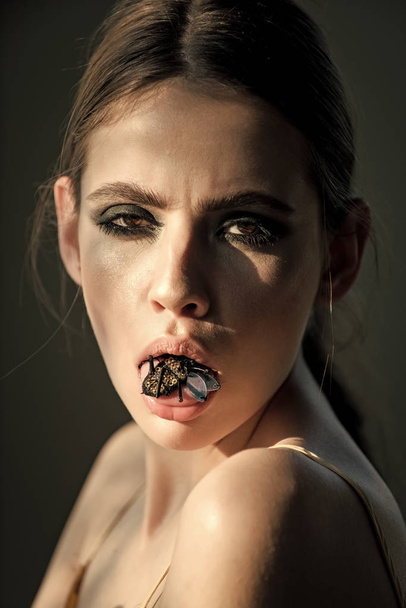 Woman with bug insect brooch in mouth - Photo, image