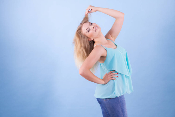 Happy positive young beautiful woman having great mood wearing blue top fashionable outfit - Foto, imagen