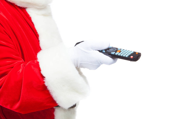Christmas. Close-up. Santa Claus in white gloves holding the TV remote control. Browse Christmas TV listings, select the channel. Isolated on white background. - 写真・画像