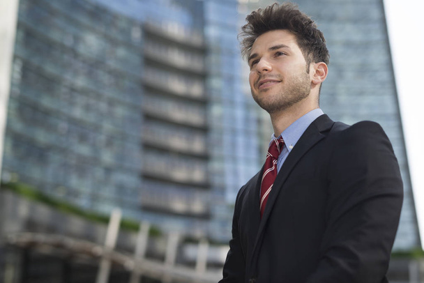 Handsome young businessman in city - Photo, image
