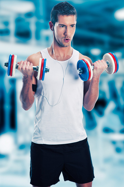Young man lifting weights on sport gym club - Foto, Imagen
