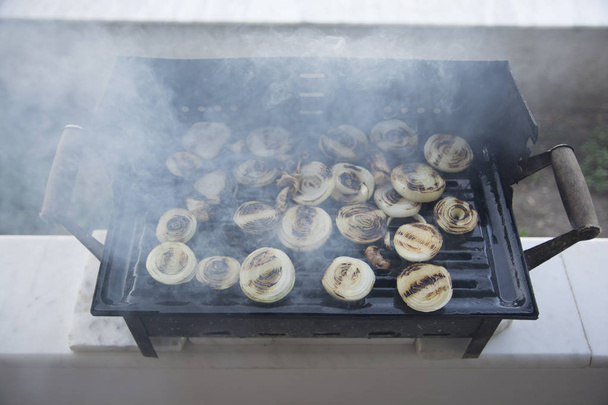 Se cocinan cebollas asadas y carne. Ahumado y hollín
 - Foto, Imagen