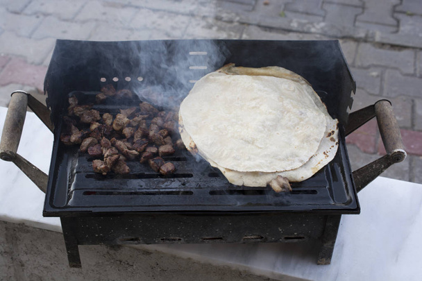 Geroosterde uien en vlees worden gekookt. Rokerige en roetzwarte - Foto, afbeelding