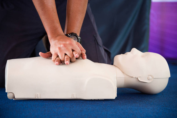 Hands of a man practicing CPR on mannequin in first aid class - Photo, Image