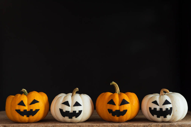 White and yellow ghost pumpkin on black background. halloween concept. - 写真・画像