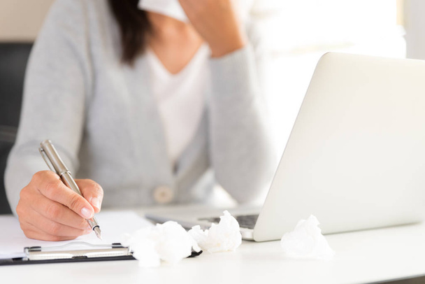 junge Geschäftsfrau krank im Büro, die Hand hält das Gewebe und niest in ein weißes Gewebe. Laptop auf dem Tisch. Gesundheitswesen und medizinisches Konzept. - Foto, Bild