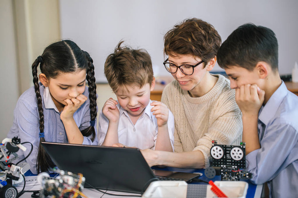 Mutlu çocuklar ders dışı derslerde dizüstü bilgisayar kullanarak programlama öğrenirler. - Fotoğraf, Görsel