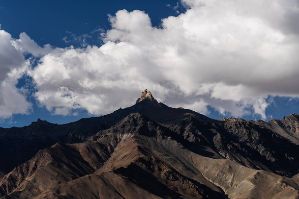 Paysage de montagne, avec lumière du soleil sur le pic et ciel bleu avec des nuages blancs
 - Photo, image