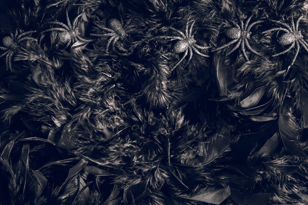 Halloween spider toys on black feathers background. - Valokuva, kuva