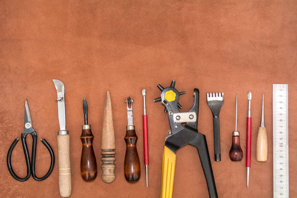 Werkzeuge zum Basteln und Stücke aus braunem Leder Layout über die Herstellung von Waren - Foto, Bild