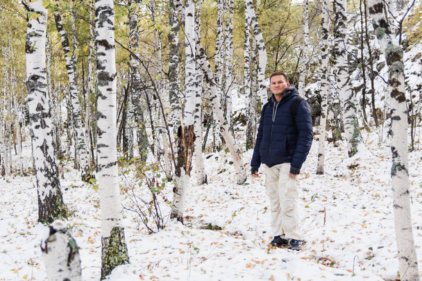 man in a jacket is in the winter Birch forest - Foto, Imagem