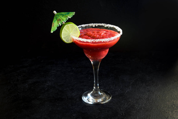 Strawberry Margarita cocktail with lime on black stone table, copy space. Frozen Margarita or Daiquiry Cocktail. - Foto, Imagen