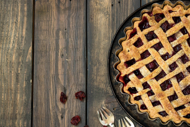 Traditional American cherry pie and mini pies on a dark wooden background - Photo, Image