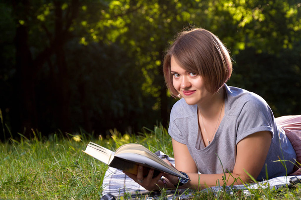 young woman reading book in park at daytime - Foto, Imagem