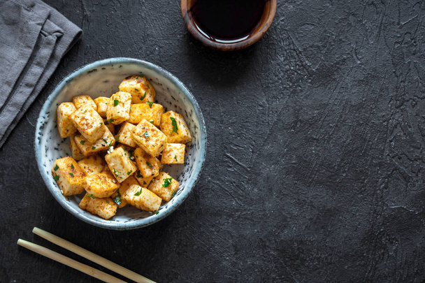 Stir Fried Tofu in a bowl with sesame and greens. Homemade healthy vegan asian meal - fried tofu. - Фото, изображение
