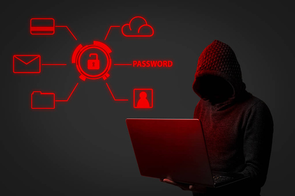 Απρόσωπη άνθρωπος σε ένα hoodie με κουκούλα κατέχει ένα φορητό υπολογιστή στα χέρια του σε σκούρο φόντο. Έννοια του hacking και κλοπή δεδομένων χρήστη. Hacked κλειδαριά, πιστωτική κάρτα, σύννεφο, ηλεκτρονικού ταχυδρομείου, κωδικοί πρόσβασης, προσωπικά αρχεία. - Φωτογραφία, εικόνα