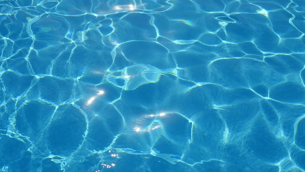 Maravillosa piscina de agua que brilla con sus olas azules cielo en movimiento Una vista asombrosa de las aguas turquesas oscilantes en una piscina aireada con líneas curvas brillantes que hacen un fondo alegre y artístico
.  - Metraje, vídeo