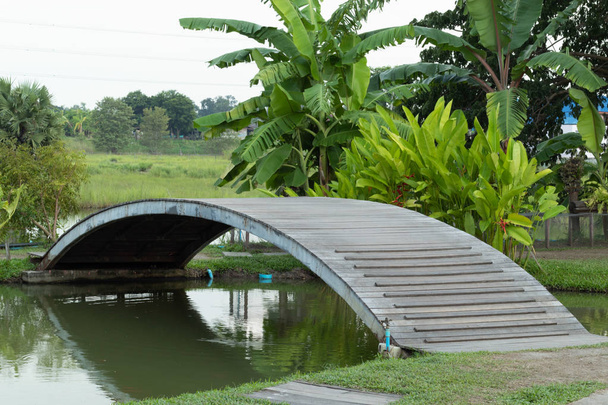 Деревянный мост через канал в саду
. - Фото, изображение