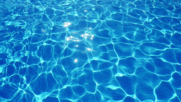 Oslnivě zářící s jeho hraním azurové vlny v slo-mo A nádherný pohled zábavné azurové vody v bazénu s třpytivými a měnící mřížkou tvoří optimistické nakřivo pozadí vody bazén.  - Záběry, video