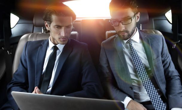 business partners sitting in a luxury car - Фото, изображение