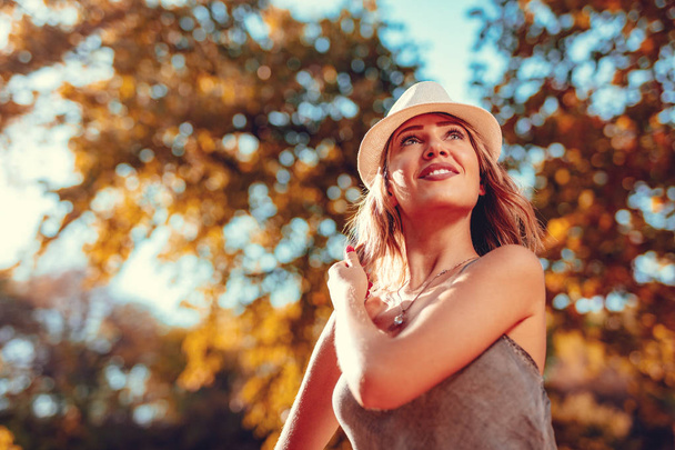 暖かい秋の公園を楽しんでいる若い女性を笑顔  - 写真・画像