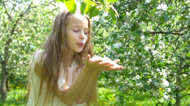 Suloinen pieni tyttö kukkiva omena puutarha kaunis kevät päivä - Materiaali, video