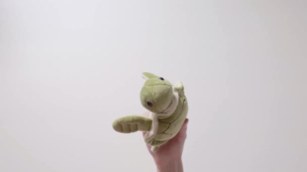 Child plays with a soft green turtle toy. Part_09. Child's hand with toy closeup. - Materiaali, video