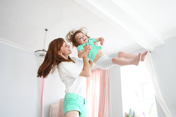 Young woman having fun with daughter indoors - Φωτογραφία, εικόνα