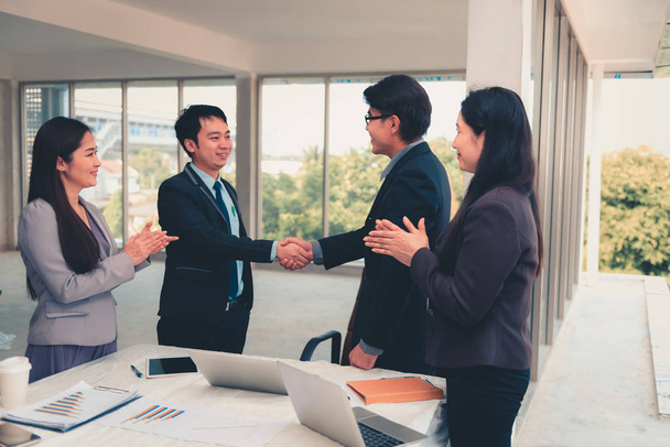 Businesspeople shaking hands together after dealing project complete. - 写真・画像