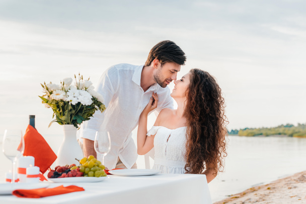 beautiful couple kissing on romantic date on seashore - Foto, imagen