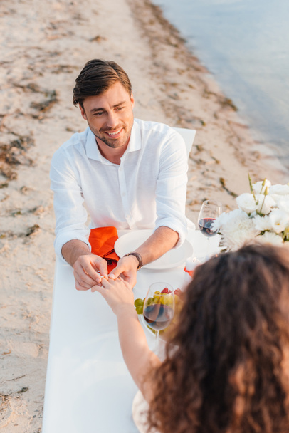 όμορφος άνδρας φοράει δαχτυλίδι στο δάχτυλο του γυναικείου μετά προτείνει την ρομαντική ημερομηνία  - Φωτογραφία, εικόνα