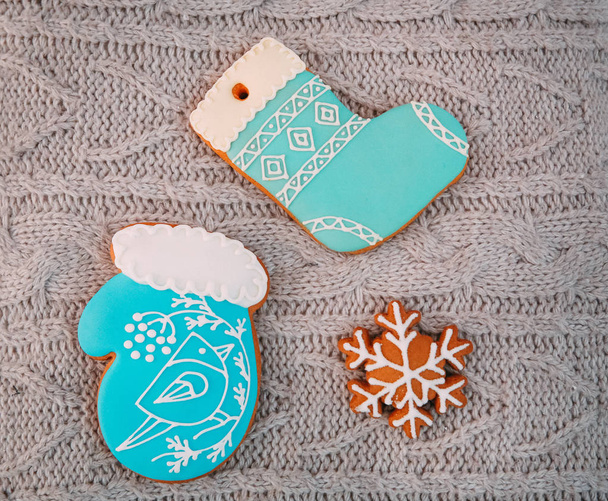 Christmas gingerbread decorated with frosting blue mitten of boots and snowflake - 写真・画像