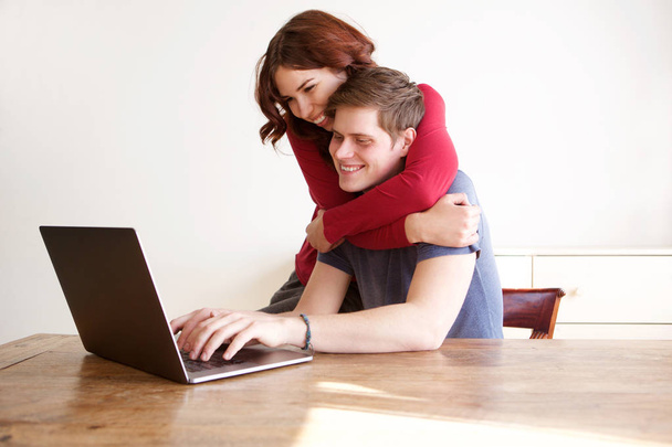 Portrait of happy boyfriend and girlfriend using laptop computer at home - Photo, Image