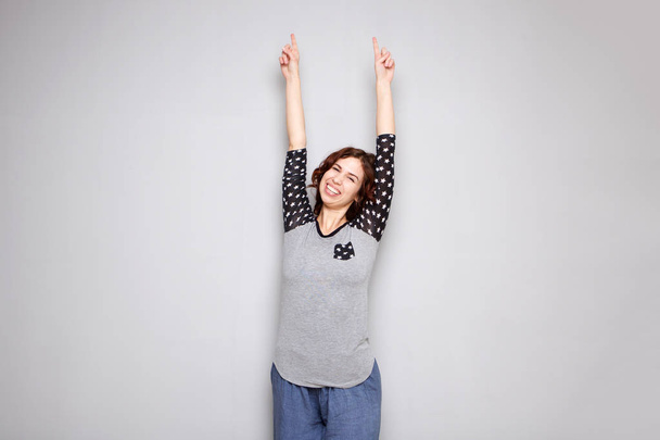 Портрет веселой молодой женщины с поднятыми руками
 - Фото, изображение