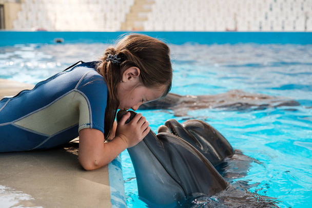 dívka líbání skákavý. Dolphin asistované léčby - Fotografie, Obrázek