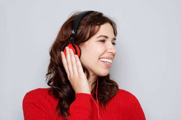 Nahaufnahme Porträt einer glücklichen jungen Frau, die mit Kopfhörern Musik hört - Foto, Bild