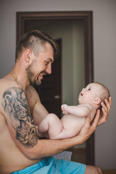 Portrait of happy Young father holding baby at home - 写真・画像