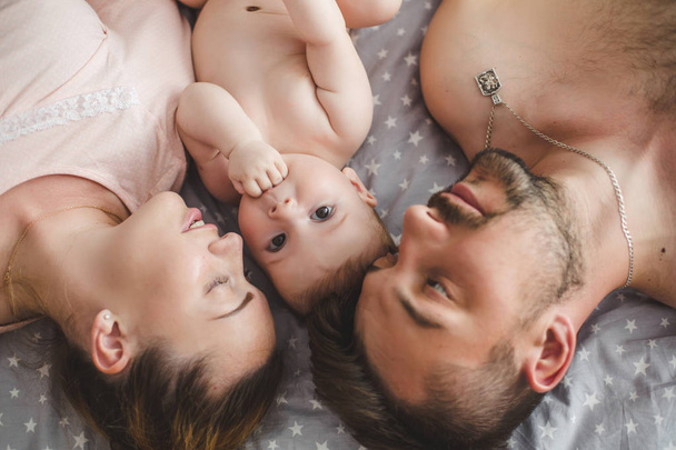 Portrait of happy young parents with baby  at home - Fotografie, Obrázek