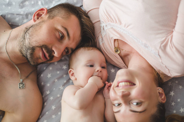 Portrait of happy young parents with baby  at home - Фото, изображение