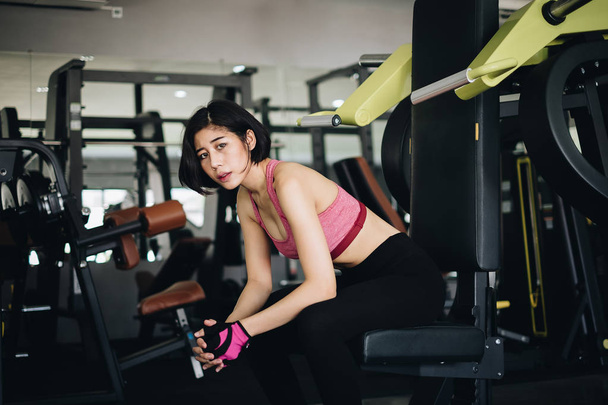 Привлекательная спортивная женщина расслабляется после тренировки в тренажерном зале. Портретный спорт и здоровая концепция
. - Фото, изображение