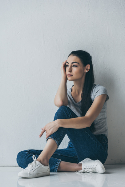 full length view of beautiful frustrated brunette woman sitting and looking away  - Photo, Image