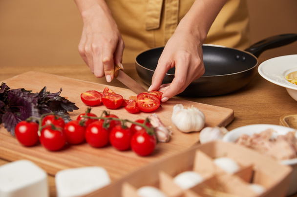 cropped shot of woman in apron cutting cherry tomatoes for pasta - Fotoğraf, Görsel