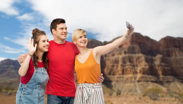 amigos tomando selfie por teléfono inteligente y abrazos
 - Foto, imagen